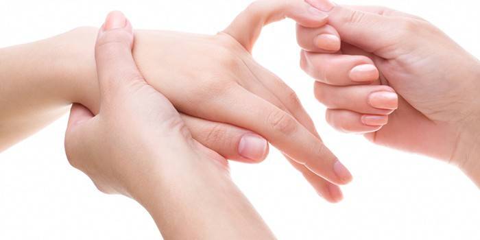 Девушке делают массаж пальцев рук