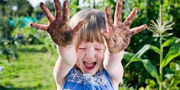 Девочка показывает грязные ладошки