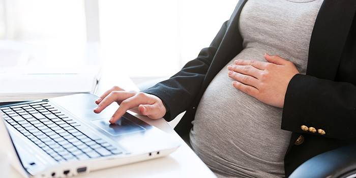 Беременная женщина за ноутбуком