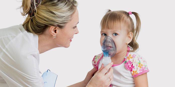 Врач держит кислородную маску у лица ребенка