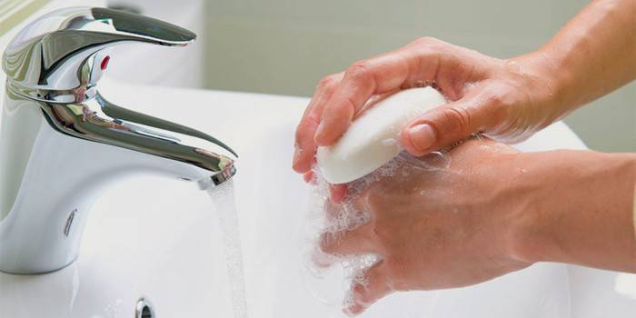 Мужчина моет руки с мылом