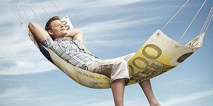 Мужчина лежит в гамаке из купюры в 100 евро