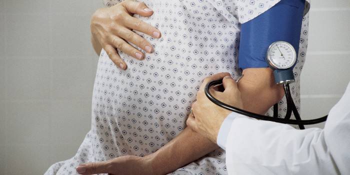 Медик измеряет АД у беременной