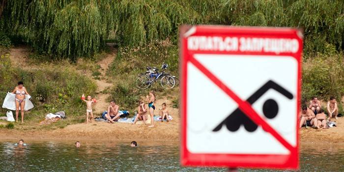 Люди отдыхают на берегу водоема