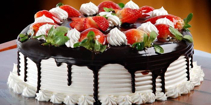 Торт покрытый шоколадной глазурью и украшенный сверху ягодами
