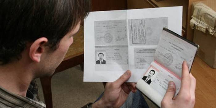 Паспорт и ксерокопия в руках у мужчины