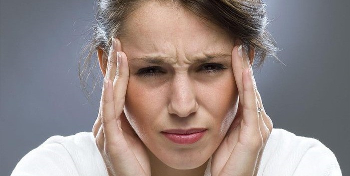 Женщина держится за голову