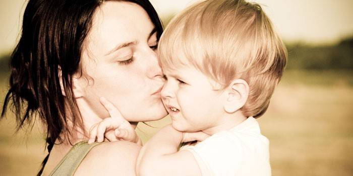 Мать целует ребенка