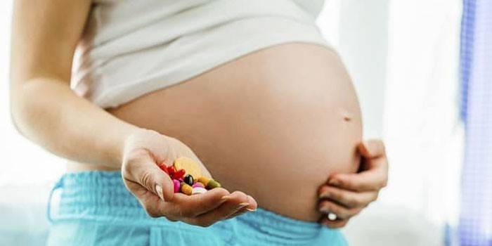 Беременная женщина с таблетками