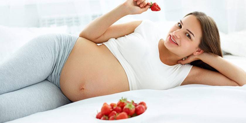 Беременная женщина с клубникой
