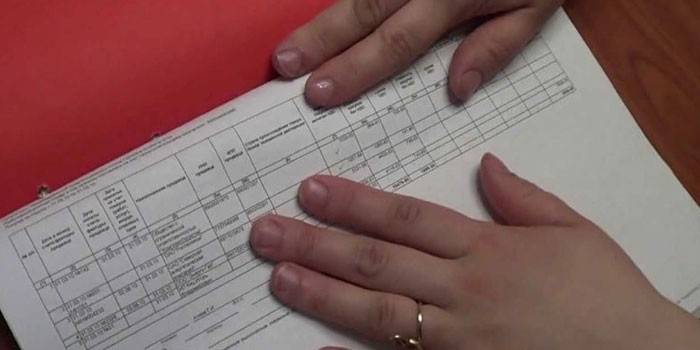 Женщина положила руки на учетную тетрадь
