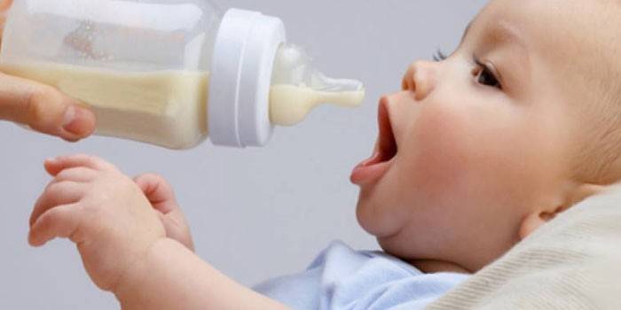 Ребенка кормят смесью из бутылочки