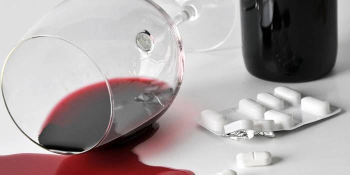 Опрокинутый бокал вина и таблетки