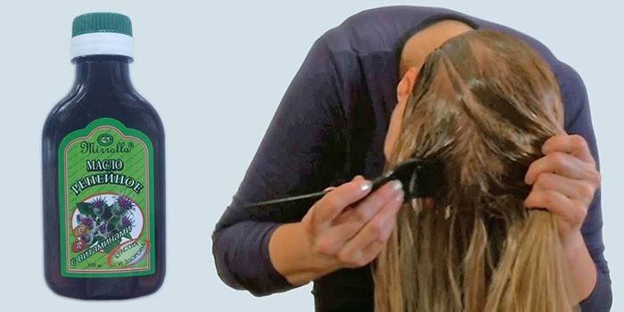 Женщина наносит на волосы репейное масло